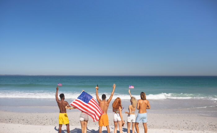 a group on the beach in the greater destin area holding a flag