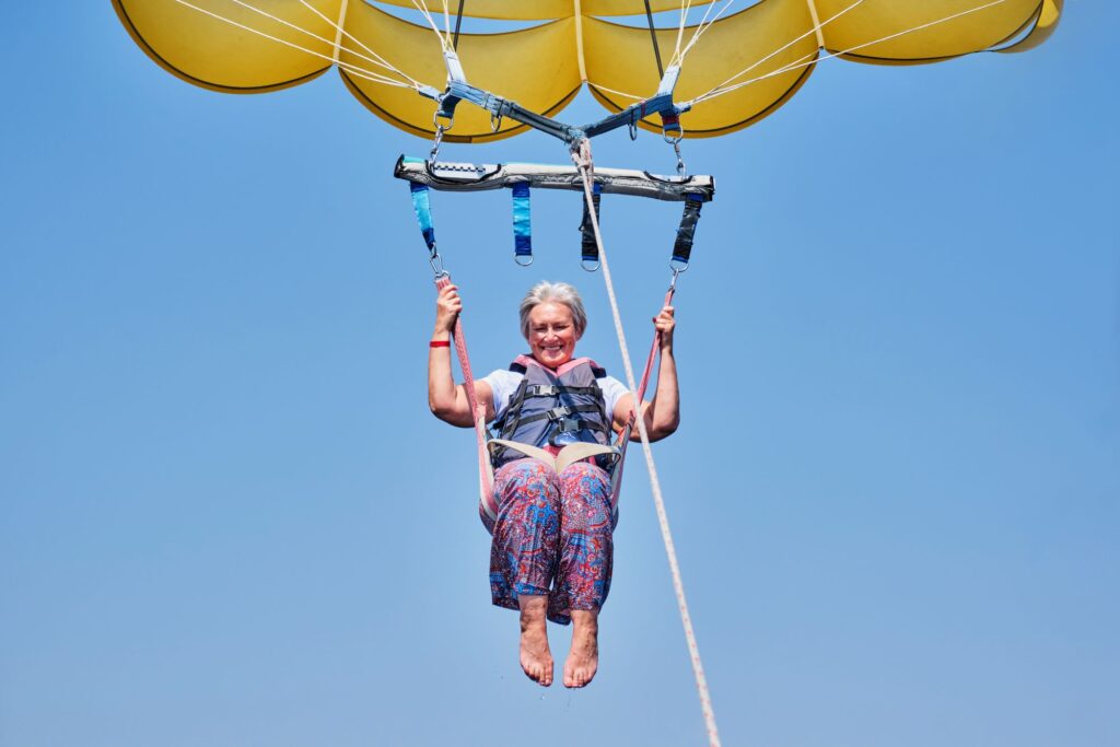 senior white woman with gray hair parasailing